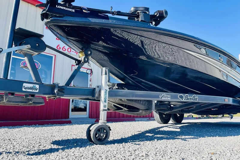 Slide: The Image of 2014 Bass Cat Eyra boat on trailer, parked outside a building. - 2