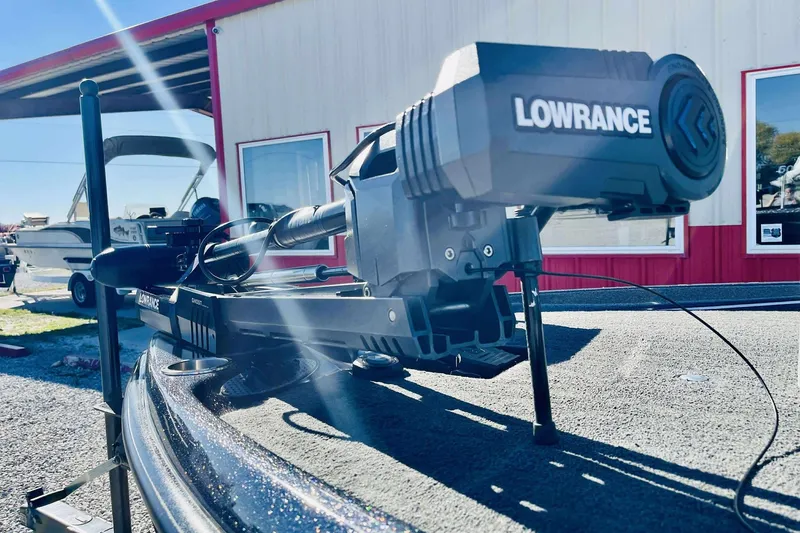 Slide: The Image of 2014 Bass Cat Eyra boat with Lowrance equipment, parked near a red and white building. - 20