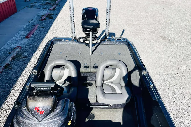 Slide: The Image of 2014 Bass Cat Eyra boat interior with dual seats and fishing equipment. - 21