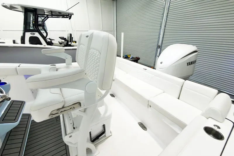 Slide: The Image of 2026 Tidewater 232 LXF boat interior with white seating and Yamaha engine in a garage. - 10