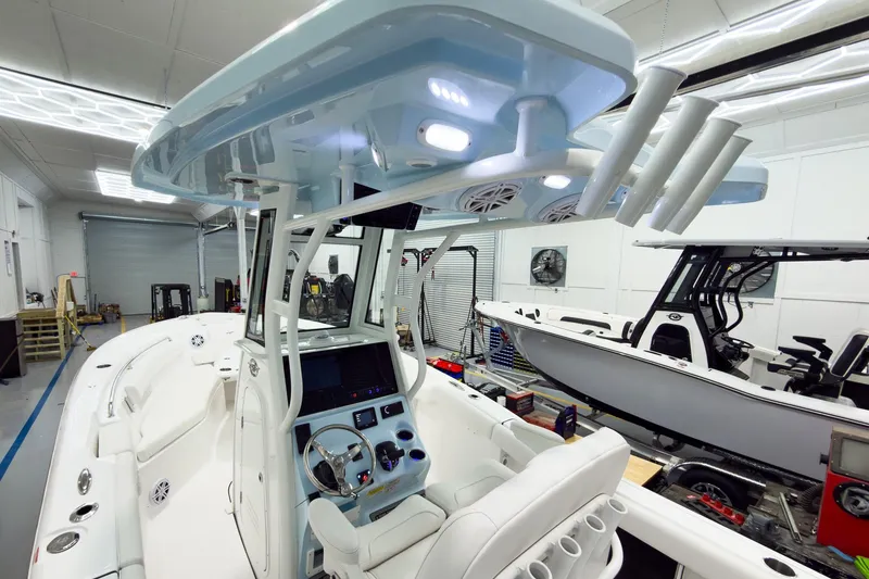 Slide: The Image of 2026 Tidewater 232 LXF boat interior with modern helm and seating in a showroom. - 15