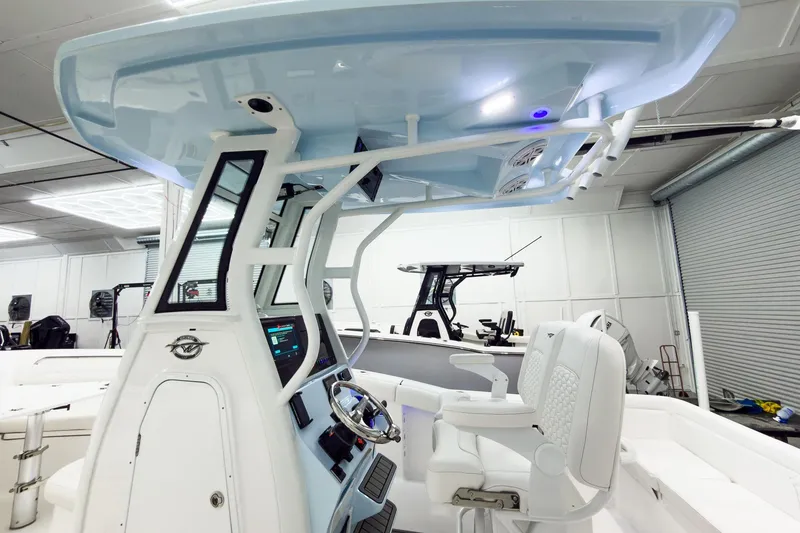 Slide: The Image of 2026 Tidewater 232 LXF boat interior with modern helm and seating in a showroom. - 29