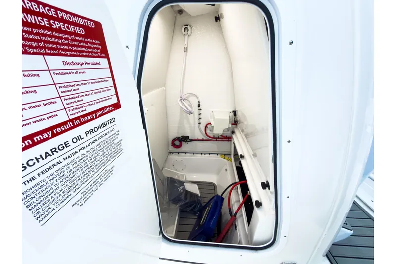 Slide: The Image of 2026 Tidewater 232 LXF boat storage compartment with safety and discharge instructions. - 30