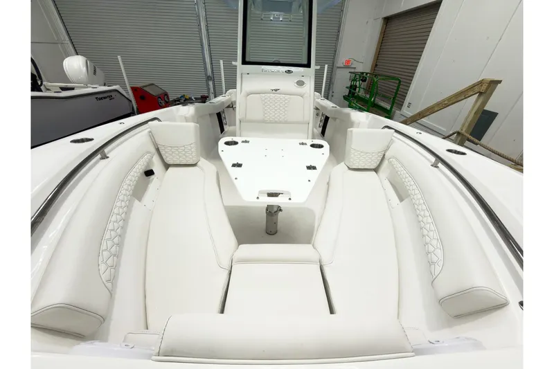 Slide: The Image of 2026 Tidewater 232 LXF boat interior with white seating and table in a showroom. - 35