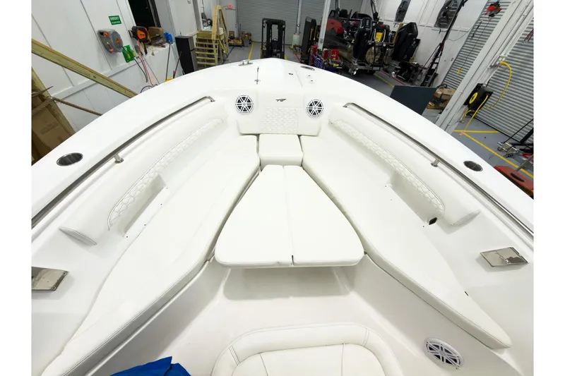 Slide: The Image of 2026 Tidewater 232 LXF boat interior with white seating and speakers in a workshop. - 38