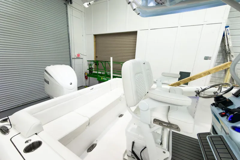 Slide: The Image of 2026 Tidewater 232 LXF boat interior with white seating and Yamaha engine in a garage. - 9