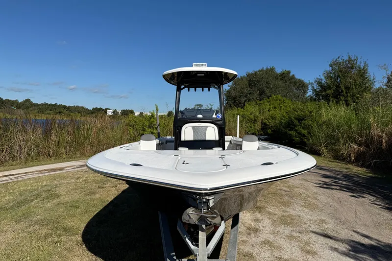Slide: The Image of 2021 Tidewater 2700 Carolina Bay boat on trailer, surrounded by lush greenery. - 11