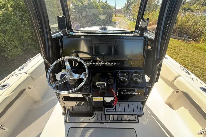 Slide: The Image of 2021 Tidewater 2700 Carolina Bay helm with dual screens and steering wheel. - 15