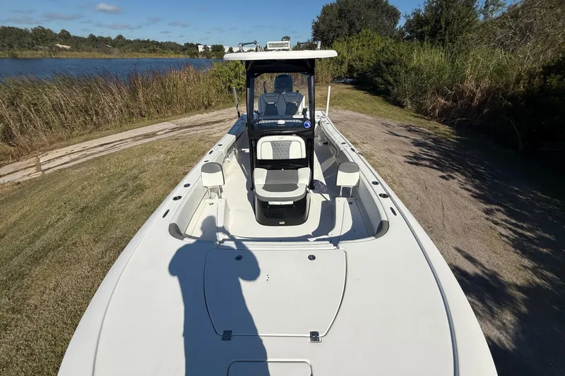Slide: The Image of 2021 Tidewater 2700 Carolina Bay boat on grassy shore near a lake. - 21