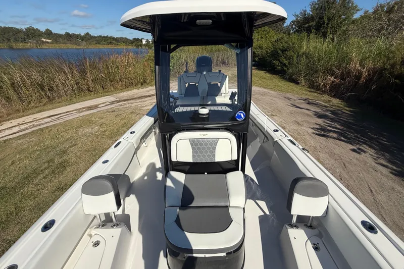 Slide: The Image of 2021 Tidewater 2700 Carolina Bay boat on a grassy path by a lake. - 22