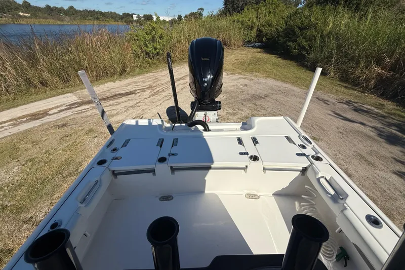 Slide: The Image of 2021 Tidewater 2700 Carolina Bay boat with outboard motor, docked near a lake. - 25