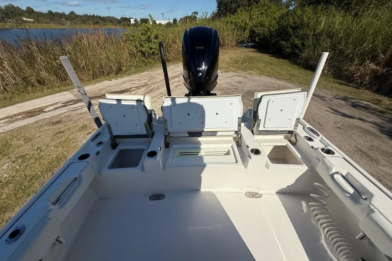 Slide: The Image of 2021 Tidewater 2700 Carolina Bay boat interior with open storage compartments and motor. - 27