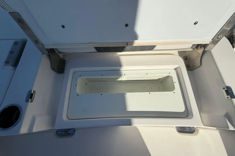 Slide: The Image of 2021 Tidewater 2700 Carolina Bay boat storage compartment, open lid, white interior. - 29
