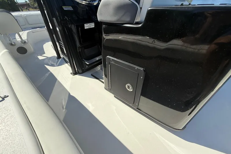 Slide: The Image of 2021 Tidewater 2700 Carolina Bay boat interior with black console and storage compartment. - 37