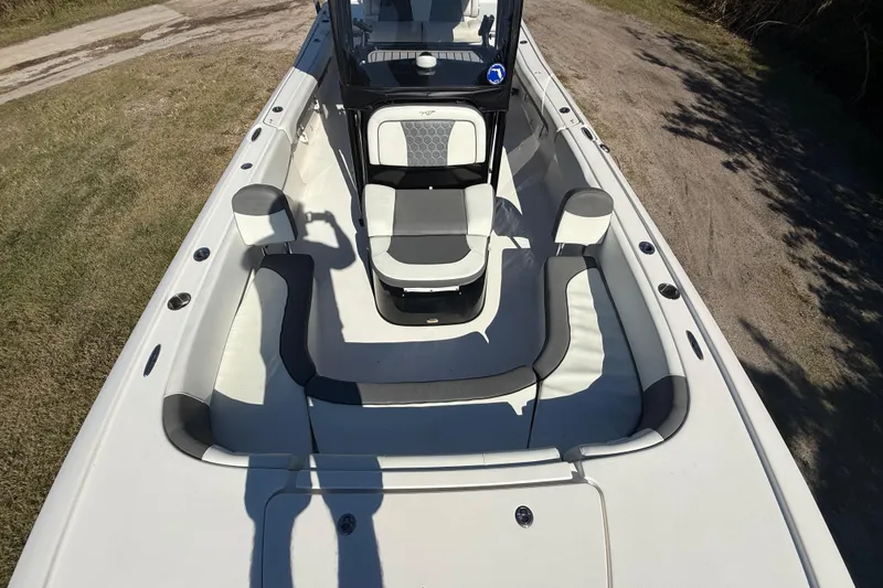 Slide: The Image of 2021 Tidewater 2700 Carolina Bay boat interior with seating and console, parked on grass. - 44