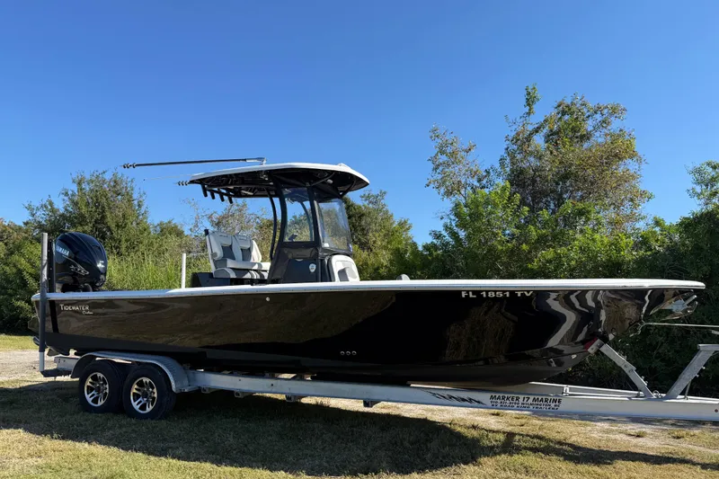 Slide: The Image of 2021 Tidewater 2700 Carolina Bay boat on trailer, parked outdoors under clear blue sky. - 9