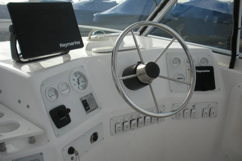 Slide: The Image of 2005 Baha Cruisers 299 SF boat helm with Raymarine electronics and steering wheel. - 11
