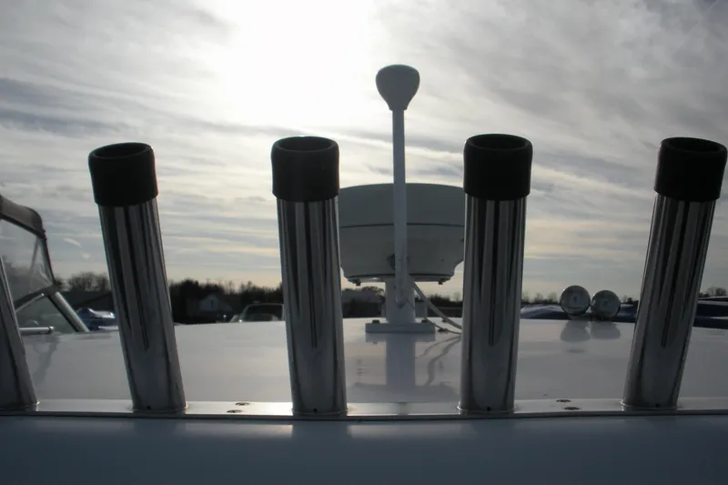 Slide: The Image of 2005 Baha Cruisers 299 SF boat with rod holders and radar against cloudy sky. - 4