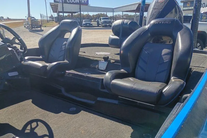 Slide: The Image of 2022 Tracker boat interior with black leather seats in outdoor setting. - 12