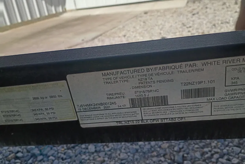 Slide: The Image of Label on a 2022 Tracker trailer, detailing specifications and manufacturing information. - 13