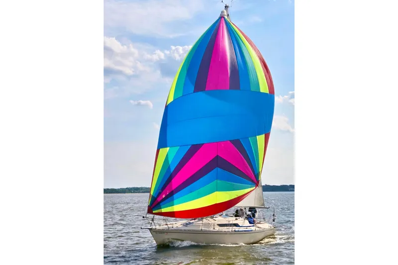 The Image of Colorful spinnaker sail on 1981 Beneteau First 32 yacht, sailing on open water. - 0