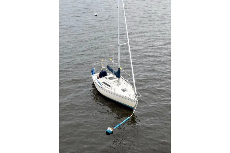 Slide: The Image of 1981 Beneteau First 32 sailboat moored on calm water. - 3