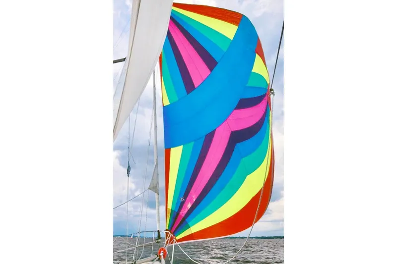 Slide: The Image of Colorful spinnaker sail on 1981 Beneteau First 32 yacht, vibrant sailing scene. - 4