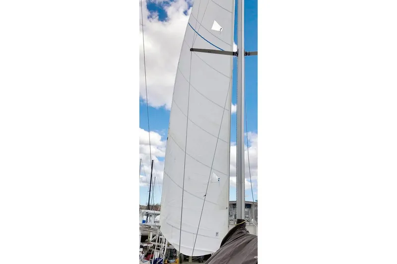 Slide: The Image of Sail of 1981 Beneteau First 32 yacht against a blue sky with clouds. - 5