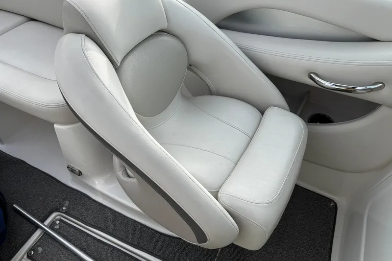 Slide: The Image of 2008 Chaparral 256 SSi boat interior with white leather seating and chrome handle. - 13