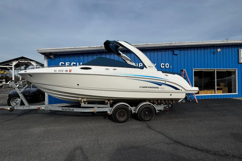 Slide: The Image of 2008 Chaparral 256 SSi boat on trailer outside blue building. - 2
