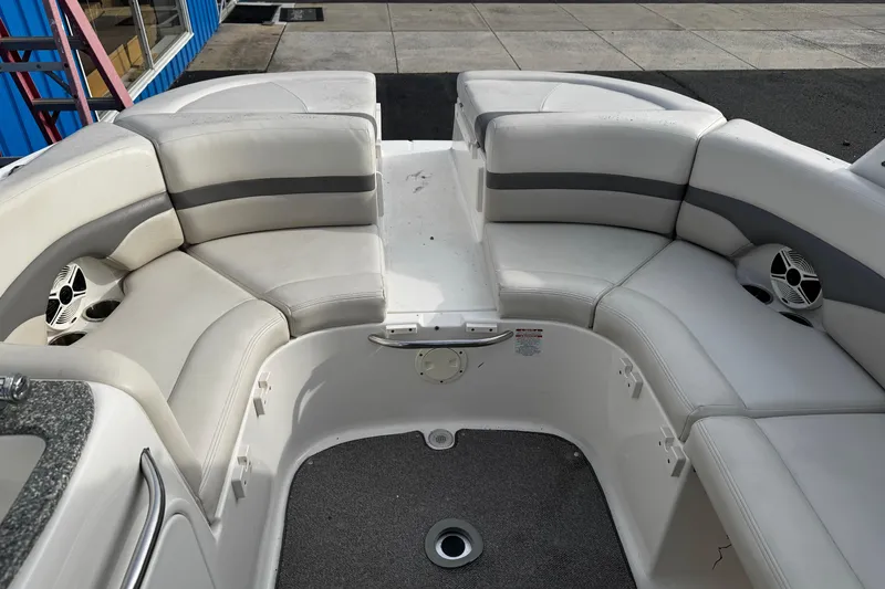 Slide: The Image of 2008 Chaparral 256 SSi boat interior with white cushioned seating and built-in speakers. - 5