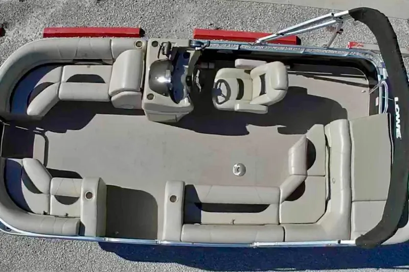 Slide: The Image of 2015 Lowe SS 210 pontoon boat with beige seating and steering console, aerial view. - 2