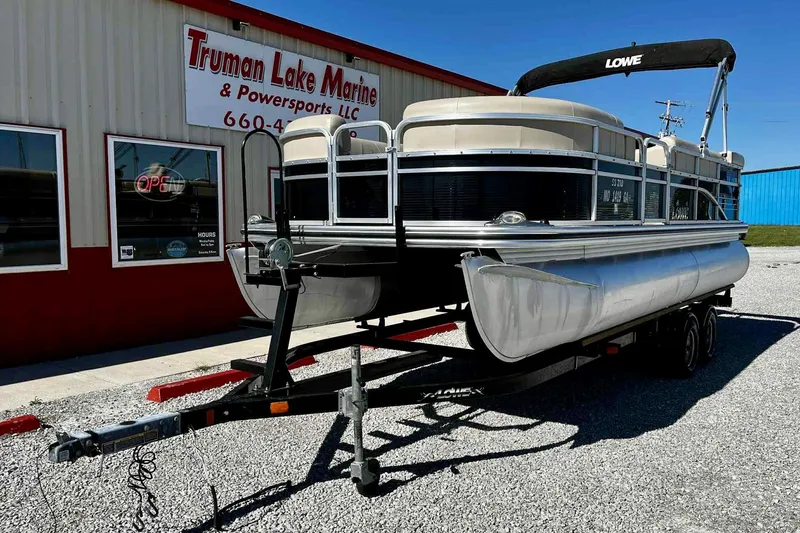 Slide: The Image of Interior of a 2015 Lowe SS 210 pontoon boat with beige seating and steering console. - 7