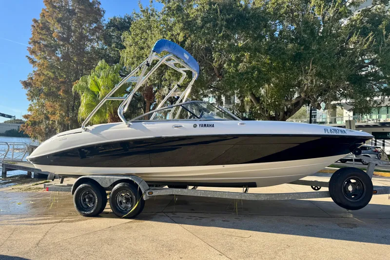 Slide: The Image of 2005 Yamaha Boats SX230 on trailer, parked near water with trees in background. - 17