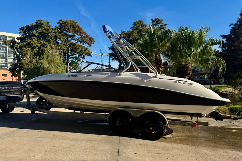 Slide: The Image of 2005 Yamaha Boats SX230 on trailer, parked near palm trees under clear blue sky. - 19