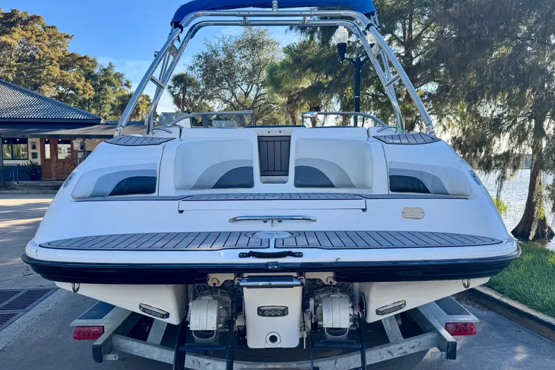 Slide: The Image of 2005 Yamaha Boats SX230 on trailer, rear view with trees and water in background. - 20