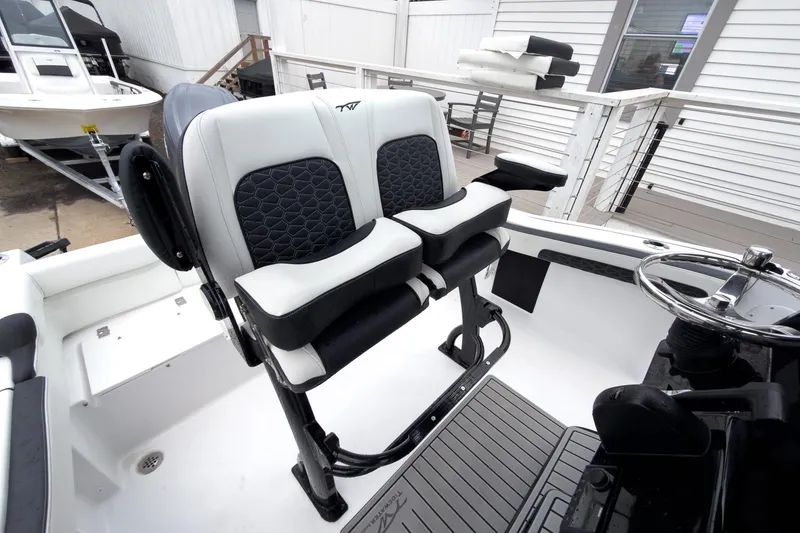 Slide: The Image of 2026 Tidewater 210 LXF boat interior with dual seats and steering wheel. - 18