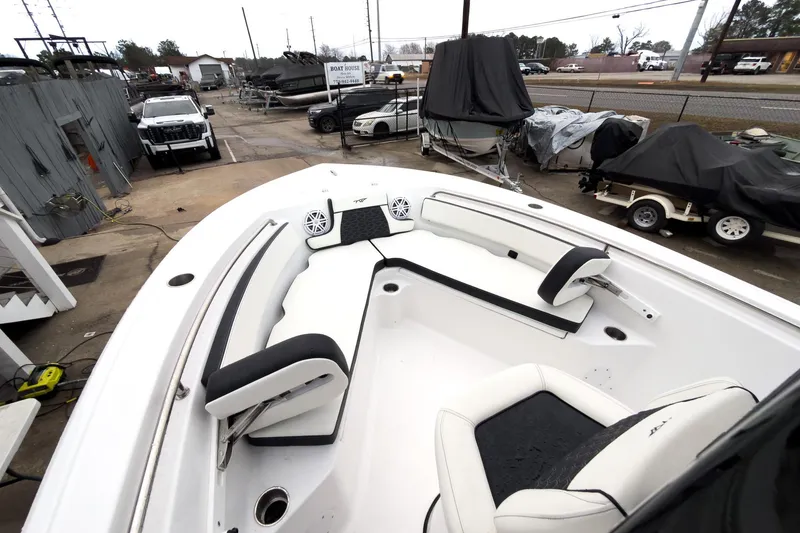 Slide: The Image of 2026 Tidewater 210 LXF boat interior with white seating, parked in a marina. - 30