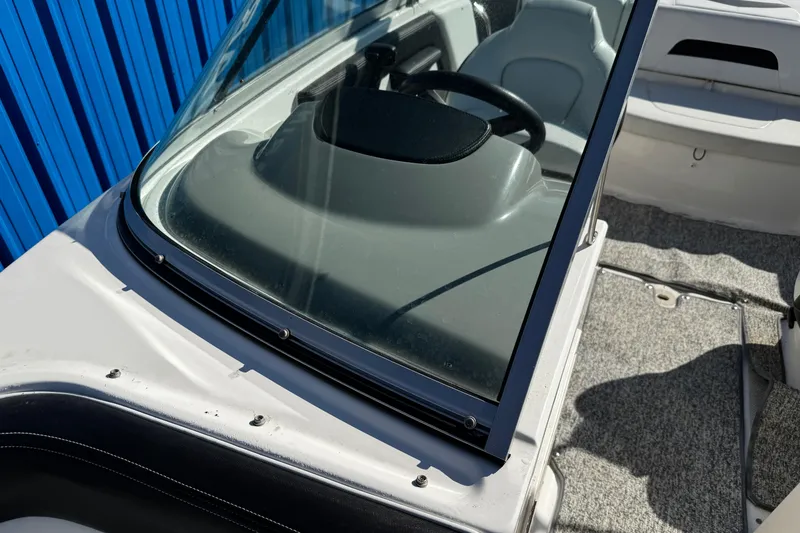 Slide: The Image of 2016 Chaparral 21 H2O Sport boat interior with steering wheel and seating. - 16