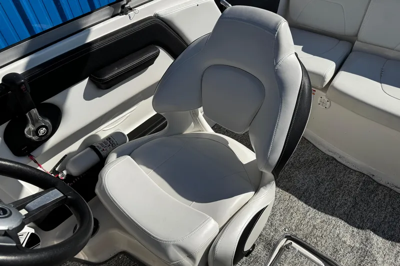 Slide: The Image of 2016 Chaparral 21 H2O Sport boat interior with white captain's seat and steering wheel. - 21