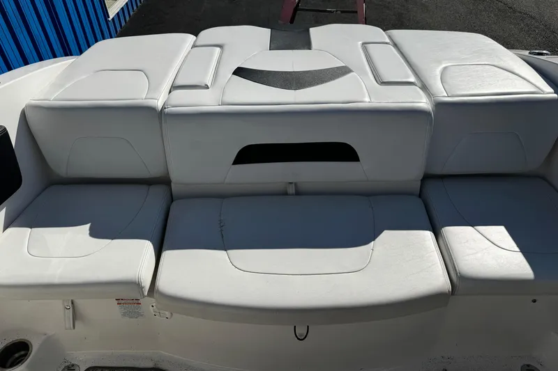 Slide: The Image of 2016 Chaparral 21 H2O Sport boat with white cushioned seating, outdoor view. - 23