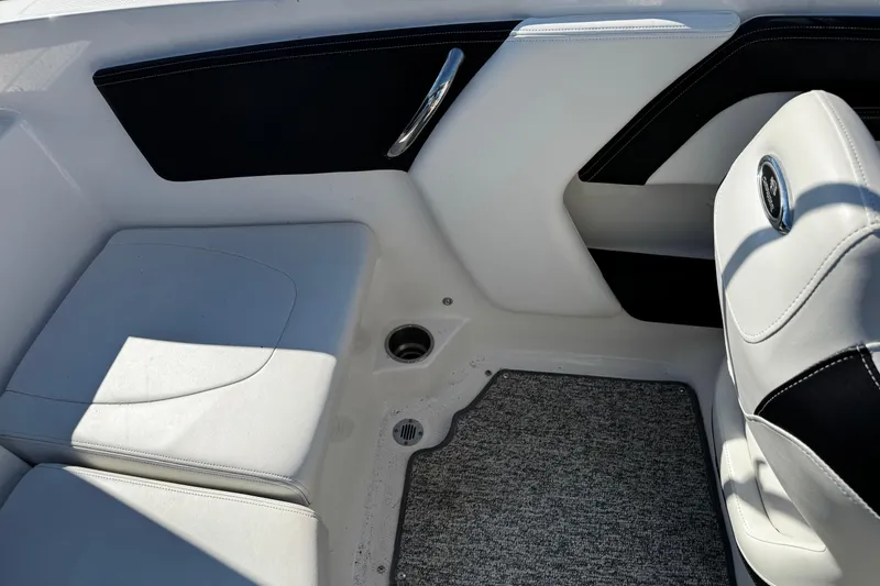 Slide: The Image of Interior of 2016 Chaparral 21 H2O Sport boat, featuring white seating and carpeted flooring. - 33