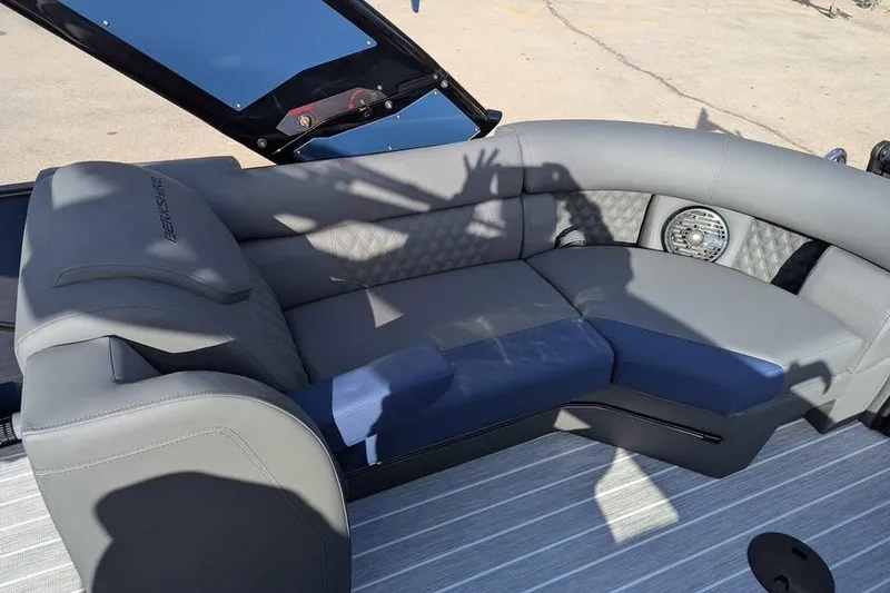 Slide: The Image of 2026 Berkshire 23RFX STS boat interior with gray and blue seating, speaker, and shadow. - 18