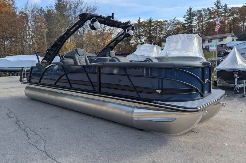 Slide: The Image of 2026 Berkshire 23RFX STS pontoon boat in a marina setting, surrounded by trees. - 2