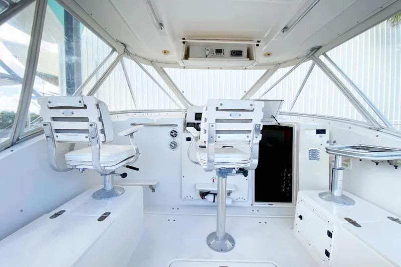 Slide: The Image of 2001 Pursuit 3000 Offshore boat cockpit with white seating and control panel. - 13