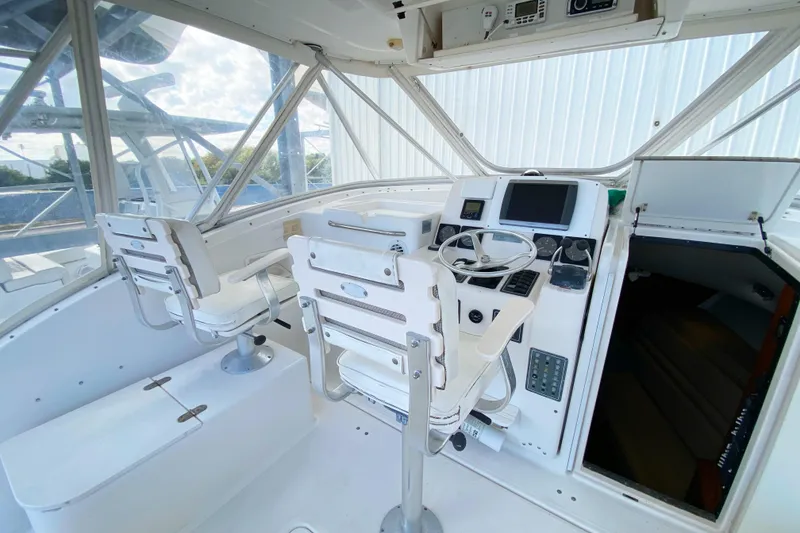 Slide: The Image of 2001 Pursuit 3000 Offshore boat cockpit with steering wheel and dual captain chairs. - 14