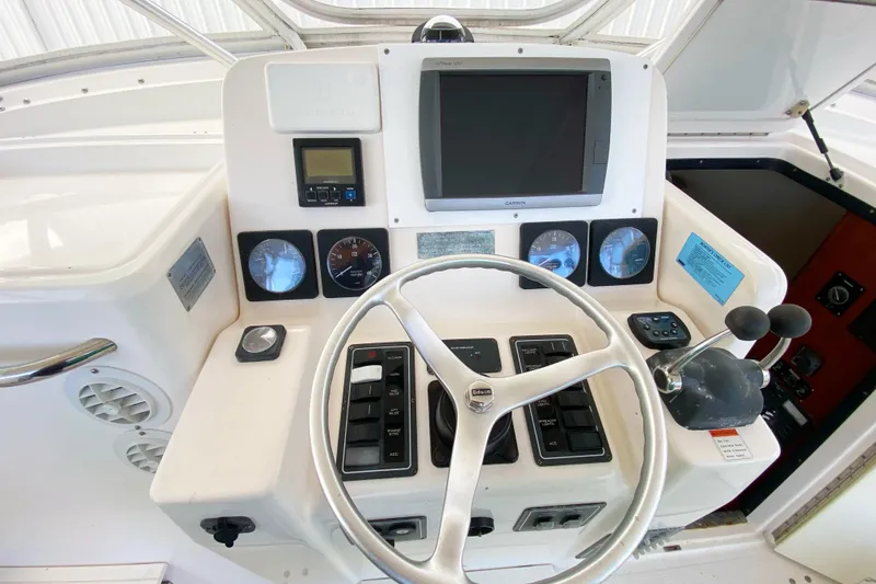 Slide: The Image of Control panel of a 2001 Pursuit 3000 Offshore boat with steering wheel and gauges. - 17