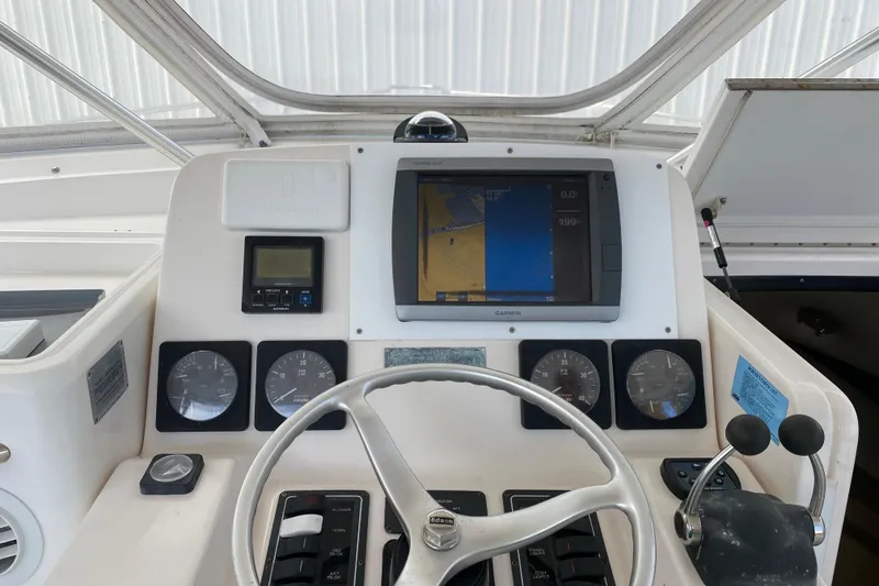 Slide: The Image of Helm of 2001 Pursuit 3000 Offshore boat with navigation instruments and steering wheel. - 19