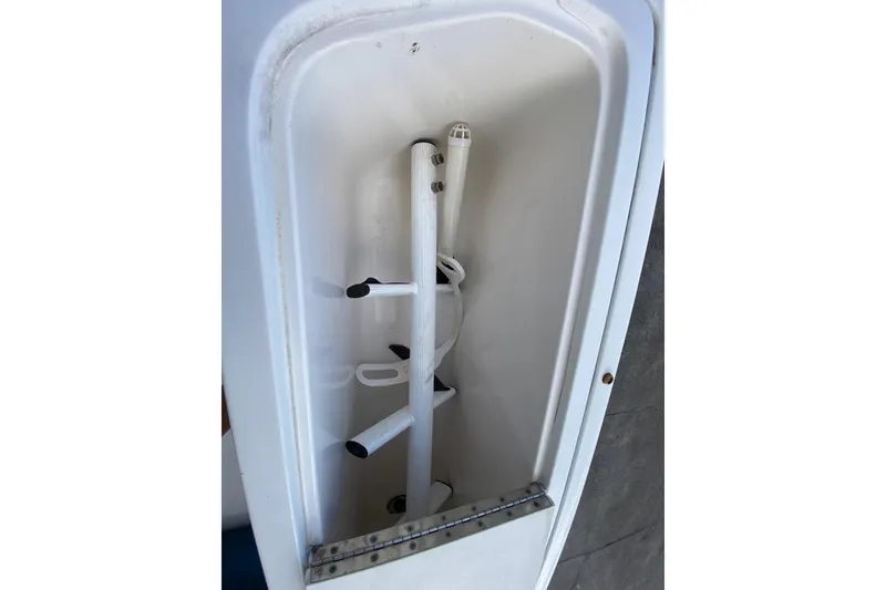 Slide: The Image of Storage compartment of a 2001 Pursuit 3000 Offshore boat, featuring rod holders. - 27