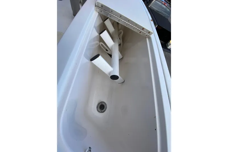 Slide: The Image of 2001 Pursuit 3000 Offshore boat storage compartment with white interior and drain. - 28